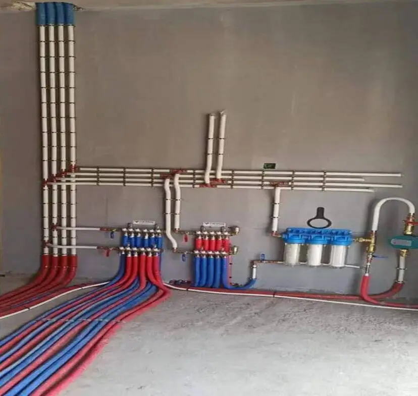 Réseau de plomberie professionnelle installé par CRD Probat avec tuyaux multicouches rouges et bleus, collecteurs et système de filtration