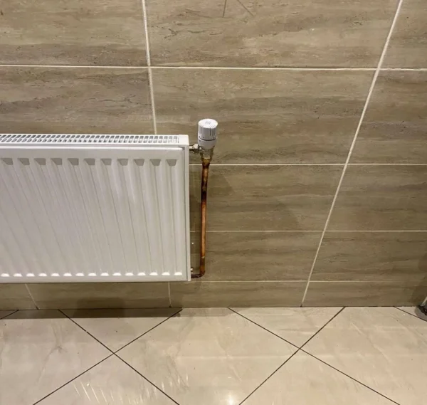 Réalisations travaux Paris - Installation radiateur blanc avec robinet thermostatique sur carrelage moderne par CRD Pro Bat